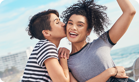 Woman giving another woman a kiss on the cheek