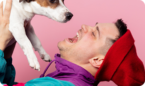 Man playfully holding a dog and shouting to it