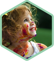 Close-up of a child smiling with paint on her face