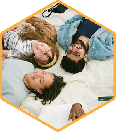 Three people lying down together, smiling at the camera