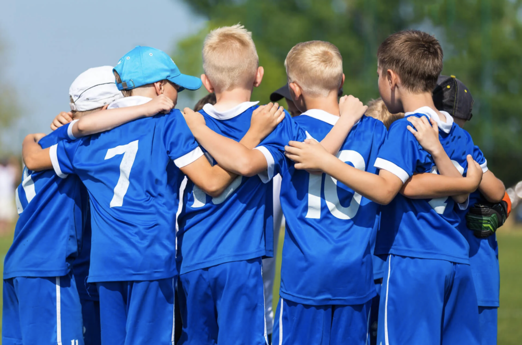 Kids in football team huddle during a game